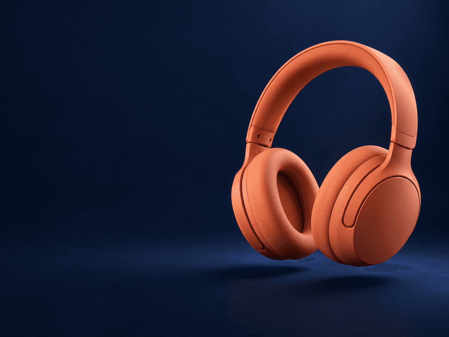 Coral headphones photographed against a deep blue studio backdrop